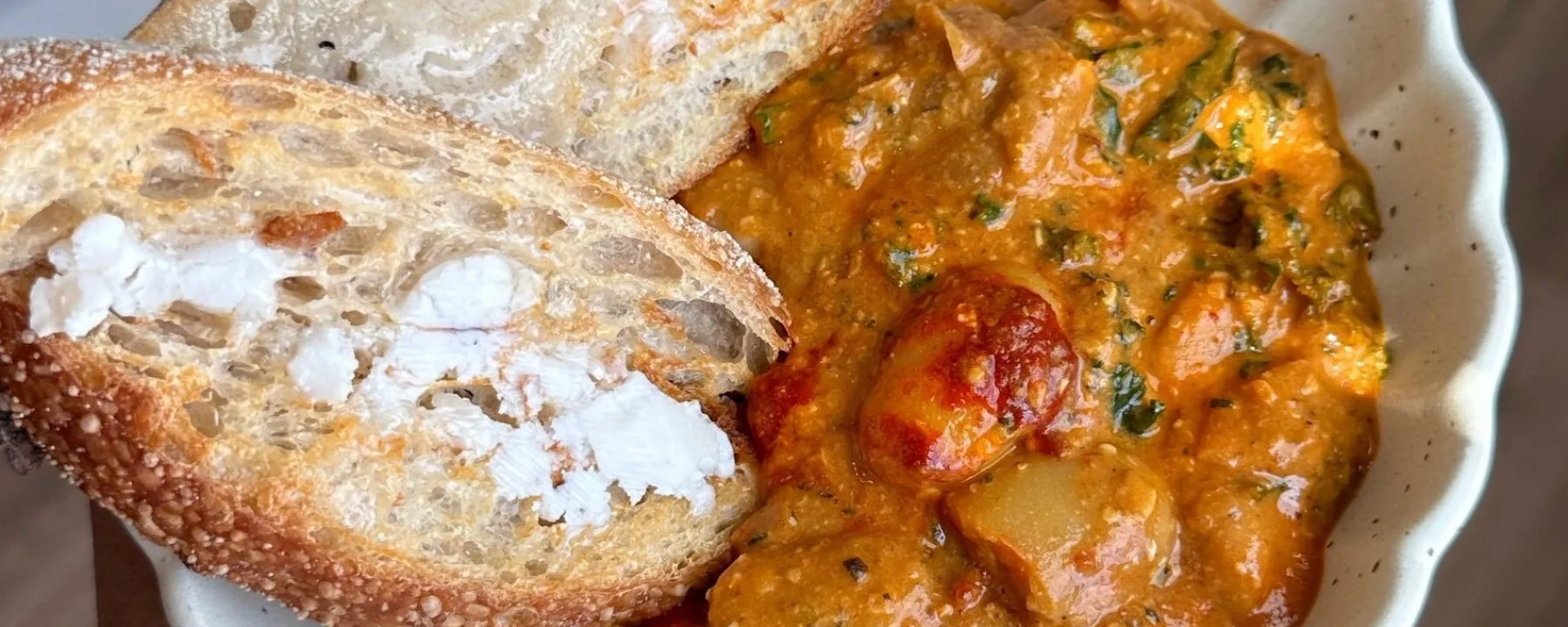 Harissa butter beans on a plate with toast.