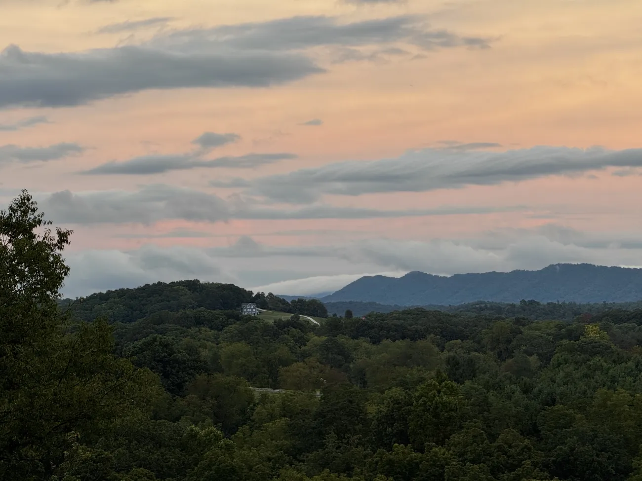 Photo: clouds pouring down the side of a mountain.